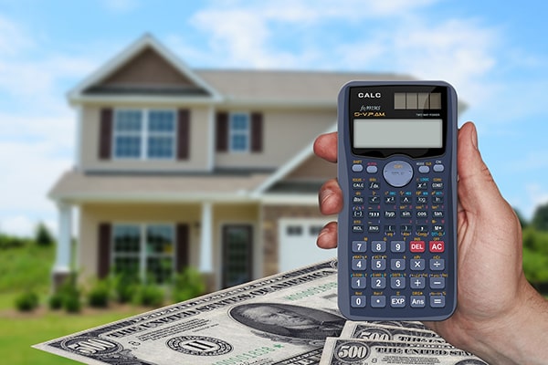 Calculator with money and home in background
